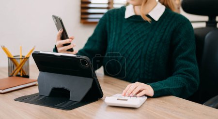 Photo for Businesswoman or accountant  typing laptop working to calculate on desk about cost at home office - Royalty Free Image