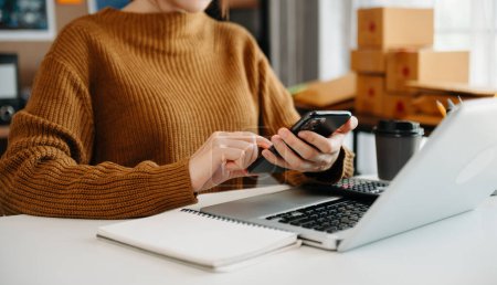 Téléchargez les photos : Woman using a laptop, smartphone  at the office of her business online shopping. - en image libre de droit