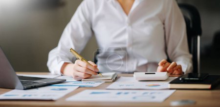 Téléchargez les photos : Femme comptant sur la calculatrice k. main tenant stylo travaillant sur la calculatrice pour calculer sur le bureau sur le coût au bureau - en image libre de droit