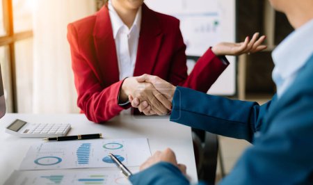 Foto de Two confident businesspeople shaking hands during a meeting in the office, success, dealing, greeting and partner in sunlight - Imagen libre de derechos