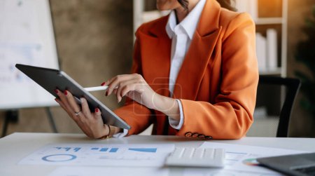 Téléchargez les photos : Femme d'affaires tapant sur tablette dans la lumière du matin ordinateur, dactylographier, en ligne dans le bureau moderne - en image libre de droit