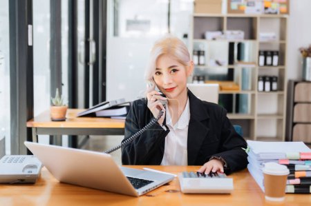 Foto de Feliz asiático mujer de negocios tienen la alegría de hablar por teléfono y portátil en la oficina - Imagen libre de derechos