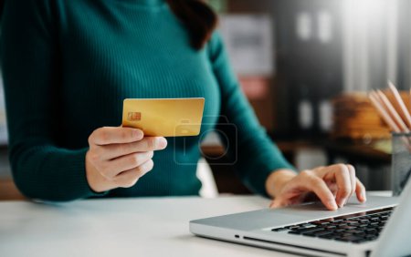 Téléchargez les photos : Femme utilisant une carte de crédit et un ordinateur portable pour les paiements mobiles - en image libre de droit