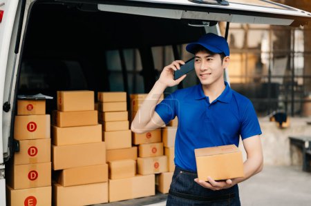 Photo for Smiling delivery man standing in front of his van with Holding Box and tablet delivery home and shipping - Royalty Free Image