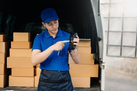 Foto de Happy delivery, Asian man standing  near van outside the warehouse. This is a freight transportation and distribution warehouse. - Imagen libre de derechos