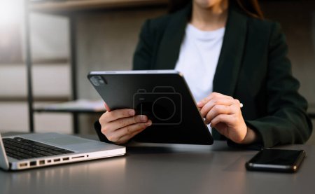 Téléchargez les photos : Femme d'affaires avec ordinateur portable, téléphone intelligent et tablette PC - en image libre de droit