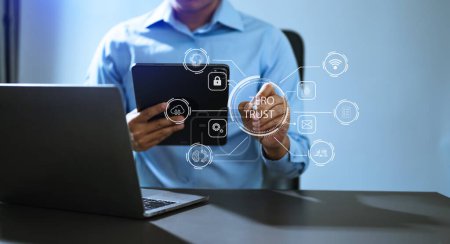Foto de Concepto de seguridad de confianza cero, hombre de negocios usando computadora y tableta con icono de confianza cero en la pantalla virtual de la oficina de Data businesses.in - Imagen libre de derechos