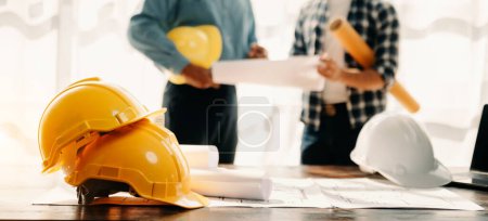 Photo for Engineer desk with object paper and  blurry engineer teamwork hardworking to consults about their building project. in office - Royalty Free Image