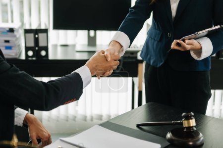 Téléchargez les photos : Avocat et client se serrant la main collaborent sur des accords de travail avec des documents contractuels au bureau - en image libre de droit