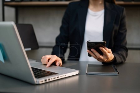 Photo for Businesswoman with laptop and smartphone in office - Royalty Free Image