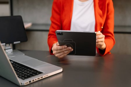 Téléchargez les photos : Femme d'affaires avec ordinateur portable et tablette PC au bureau - en image libre de droit