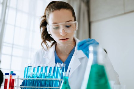 Female biotechnologist testing new chemical substances in a laboratory. Poster 646001684