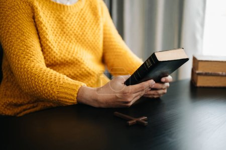 Photo for Hands together in prayer to God along with the bible In the Christian concept and religion, woman pray with the Bible on the black table - Royalty Free Image