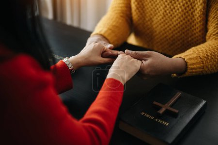 Photo for Two people reading and study bible in home and pray together.Studying the Word Of God With Friends. - Royalty Free Image