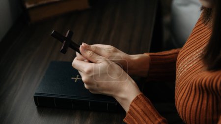 Photo for Hands together in prayer to God along with the bible In the Christian concept and religion, woman pray and Bible on the wooden table - Royalty Free Image