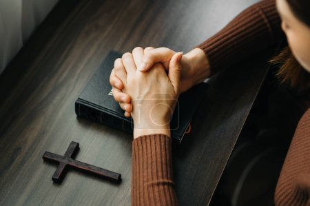Photo for Hands together in prayer to God along with the bible In the Christian concept and religion, woman pray and Bible on the wooden table - Royalty Free Image