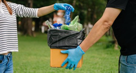 Foto de Manos sosteniendo basura poner en bolsa de reciclaje .Clearing, contaminación, ecología y concepto de plástico - Imagen libre de derechos