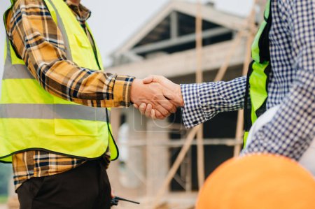 Foto de Engineer and contractor join hands after signing contract,They are having a modern building project together. successful cooperation concept - Imagen libre de derechos