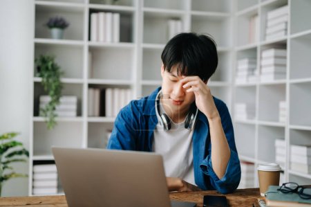 Asiatische Geschäftsmann ist gestresst, gelangweilt und überdenken von der Arbeit an einem Tablet im modernen Büro