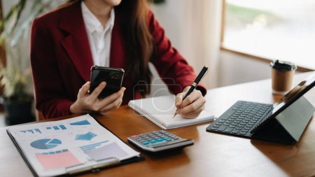 Photo for Woman  working on calculator and tablet pc at office - Royalty Free Image