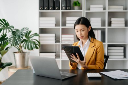 Asian businesswoman working with tablet and laptop