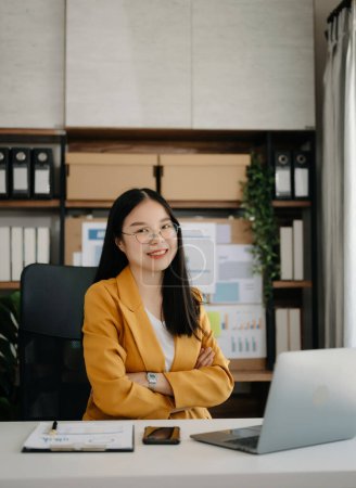 Téléchargez les photos : Asiatique femme d'affaires en utilisant un ordinateur portable au bureau - en image libre de droit