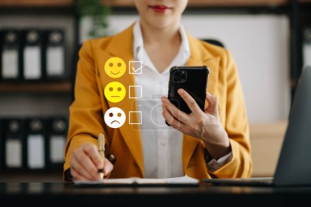 Photo for Smart woman use smartphone choosing happy smile face icon. feedback rating and positive customer review experience, mental health assessment. world mental health day concept - Royalty Free Image