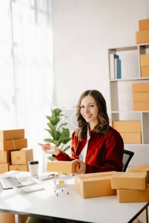 Photo for Small business entrepreneur SME freelance woman working at home office, boxes and laptop - Royalty Free Image