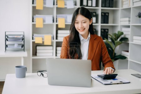Téléchargez les photos : Asiatique femme d'affaires travaillant dans le bureau avec ordinateur portable dans le bureau moderne - en image libre de droit