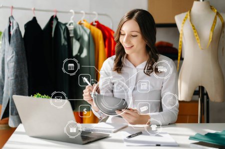 Photo for Caucasian Woman  using a laptop and tablet  at the office of her business online shopping. In home with virtual icon - Royalty Free Image