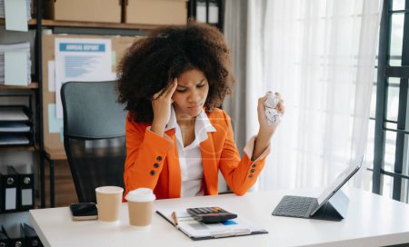 Photo for African businesswoman is stressed, bored, and overthinking from working on  tablet at the modern office - Royalty Free Image