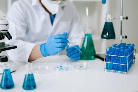 Foto de Científico mezclando líquidos químicos en el laboratorio de química. Investigador que trabaja en el laboratorio químico - Imagen libre de derechos