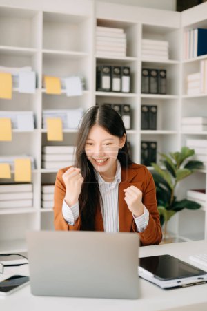 Téléchargez les photos : Femme d'affaires asiatique sont ravis et heureux avec tablette, ordinateur portable au bureau moderne - en image libre de droit