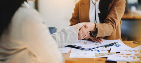 Photo for Business people shaking hands during a meeting. Two happy businesswomen in office - Royalty Free Image