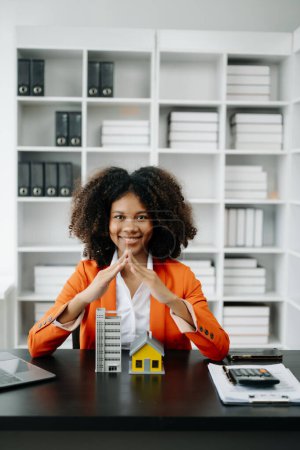 Foto de Mujer africana agente de bienes raíces. inversión inmobiliaria sobre el comercio de casa, compra en el escritorio en la oficina - Imagen libre de derechos