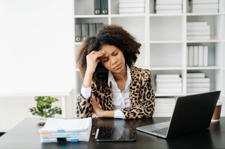 Photo for African Woman who is tired and overthinking from working with tablet and laptop at modern office - Royalty Free Image