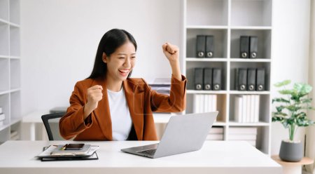 Téléchargez les photos : Femme d'affaires asiatique sont ravis et heureux avec le travail qu'ils font sur leur tablette, ordinateur portable et prendre des notes au bureau - en image libre de droit
