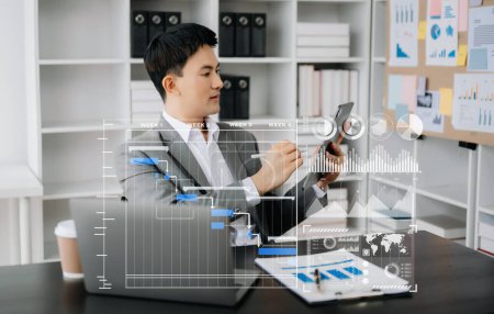 Photo for Asian Businessman working with Gantt chart scheduling virtual diagram. Man using tablet and laptop in office - Royalty Free Image