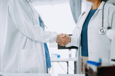 Photo for Doctor handshake and partnership in healthcare, medicine or trust for collaboration, unity or support.Team of medical experts shaking hands in teamwork for or success in clinic or hospital - Royalty Free Image