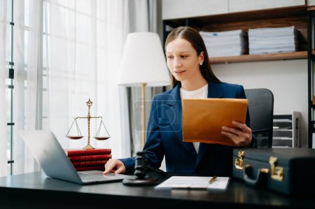 Photo for Caucasian lawyer woman at office desk with laptop and brown folder with documents, - Royalty Free Image