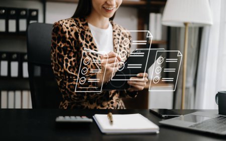 Téléchargez les photos : Image recadrée d'une femme d'affaires portant une veste léopard, assise à la table du bureau et utilisant une tablette numérique - en image libre de droit