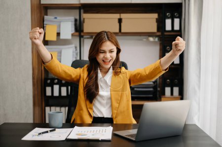 Téléchargez les photos : Femme d'affaires asiatique sont ravis et heureux avec le travail qu'ils font sur leur tablette, ordinateur portable et prendre des notes au bureau - en image libre de droit