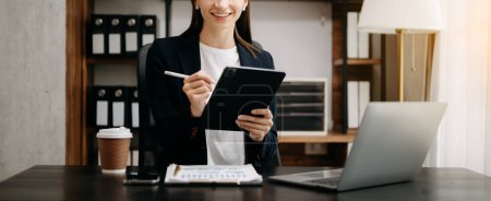 Photo for Cropped image of Business woman working at office workplace with laptop and coffee mug, woman smiling - Royalty Free Image