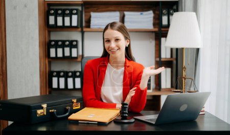Photo for Lawyer woman working at office workplace table with laptop, case, hammer and folder. smiling on camera businesswoman - Royalty Free Image