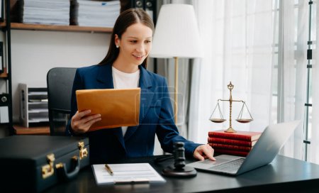 Photo for Caucasian lawyer woman at office desk with laptop and brown folder with documents, - Royalty Free Image