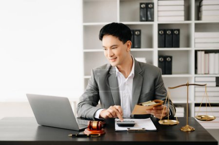 Photo for Justice and law concept. Asian businessman or lawyer or accountant working on accounts using laptop and documents in modern office - Royalty Free Image