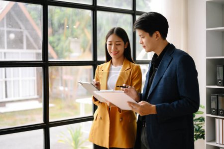 Téléchargez les photos : Deux hommes et femmes d'affaires asiatiques utilisant une tablette numérique. Professionnels travaillant au bureau. - en image libre de droit