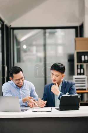Photo for Two Asian businessmen working together in modern office - Royalty Free Image