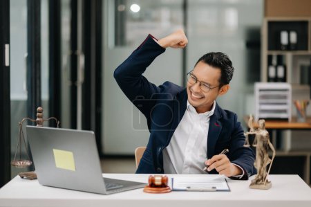 Foto de Concepto de justicia y derecho. Asiático hombre abogado trabajando en oficina, celebrando gesto - Imagen libre de derechos