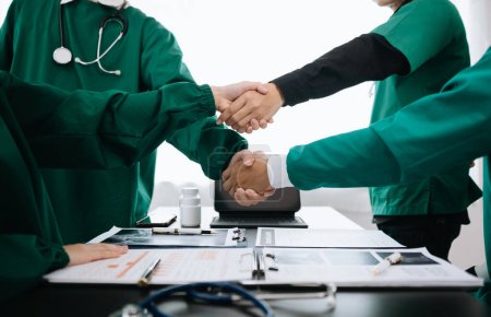 Photo for Doctor handshake and partnership in healthcare, medicine or trust for collaboration, unity or support. Team of medical experts shaking hands in teamwork for or success in hospital - Royalty Free Image